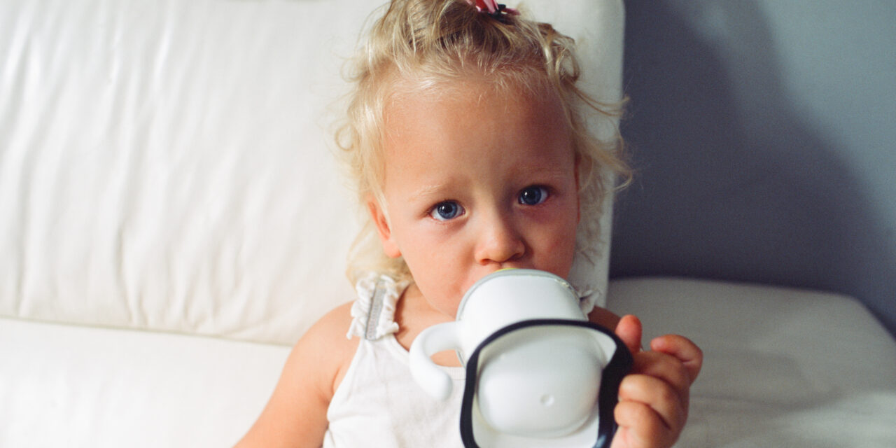 blonde toddler drinking form transition sippy cup